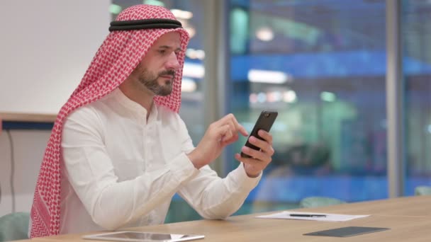 Арабский бизнесмен, использующий смартфон на работе — стоковое видео