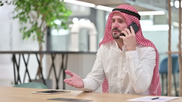 陽気なアラブビジネスマンがスマートフォンで話しています — ストック動画
