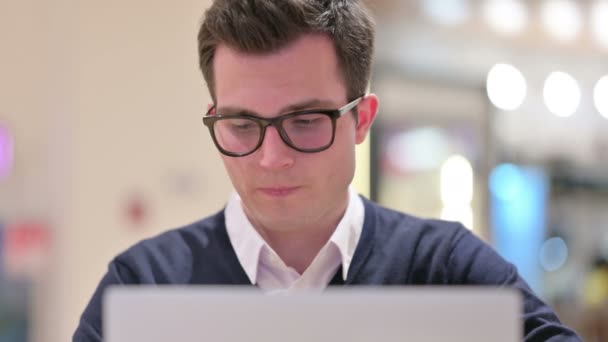 Jeune homme d'affaires avec ordinateur portable regardant la caméra — Video
