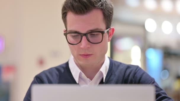 Jeune homme d'affaires avec ordinateur portable souriant à la caméra — Video