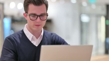 Laptop öksüren hasta genç iş adamı. 