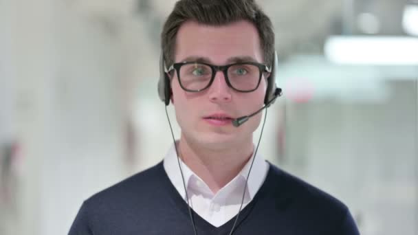 นักธุรกิจหนุ่มมืออาชีพพูดคุยเกี่ยวกับหูฟัง — วีดีโอสต็อก