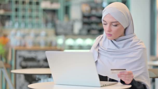 Оплата через Интернет на ноутбуке арабской женщины с помощью кредитной карты — стоковое видео