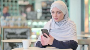 Akıllı telefon kullanan Ciddi Genç Arap Kadın 