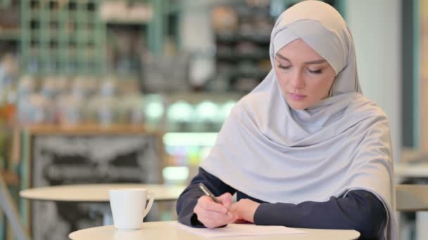 严肃的阿拉伯青年妇女在纸上写作 — 图库视频影像