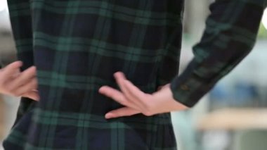 Adam iki eliyle sırt ağrısı çekiyor ve kendini tutuyor.