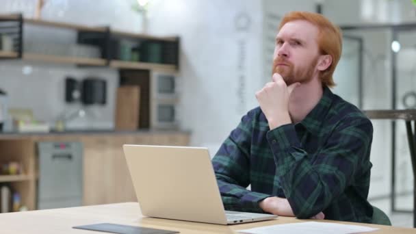 Rotschopfbärtiger Mann mit Laptop denkt nach und kommt auf eine Idee — Stockvideo