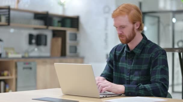 Rotschopf mit Bart feiert Erfolg am Laptop und gewinnt — Stockvideo