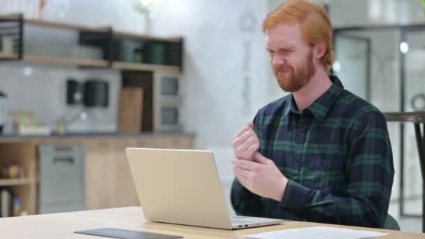 手首の痛みを持つカフェでノートパソコンを持つひげの赤毛の男 — ストック動画