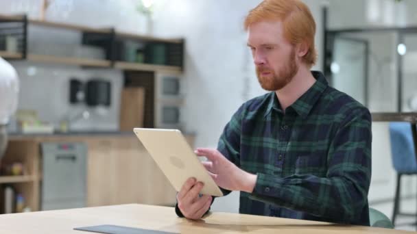 カフェでデジタルタブレットを使用して若いひげの赤毛の男 — ストック動画