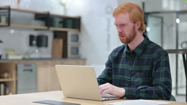 Rotschopfbärtiger Mann mit Kopfschmerzen benutzt Laptop im Café — Stockvideo