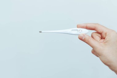 Adamın elinde termometre var.