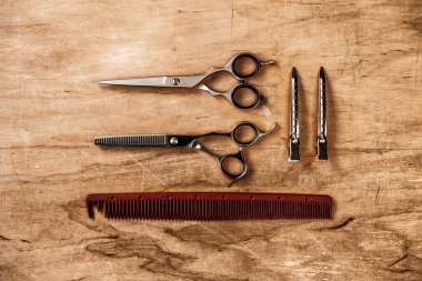 Saç ve sakal aletleri yatay olarak ahşap bir yüzeyde bulunur.