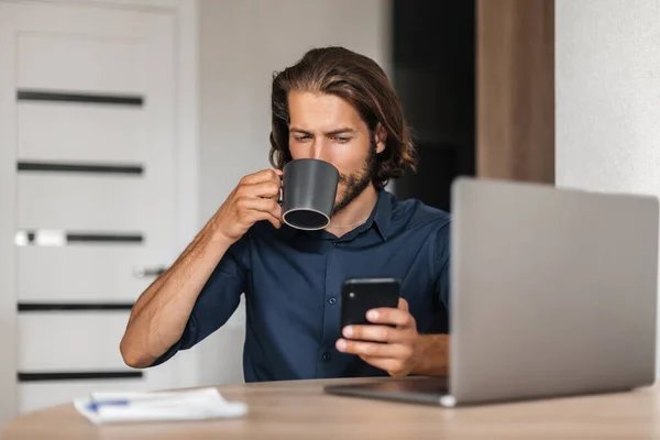 머리를 사업가 가집에서 일하면서 커피를 마시고 노트북을 탁자에 — 스톡 사진