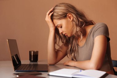 Bilgisayarda uzaktan çalışan işten yorgun genç bir kadının portresi.