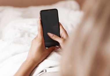 Yatakta genç bir kadın bir mesaja cevap veriyor. Kız uyandı ve telefonda arkadaşlarıyla sohbet etti..