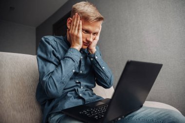 Bilgisayarda çalışan üzgün adam.