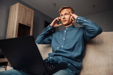 Yoğunlaşmış insan evde çalışırken düşünür.