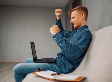 Evdeki bilgisayarda çalışan neşeli bir adamın portresi.