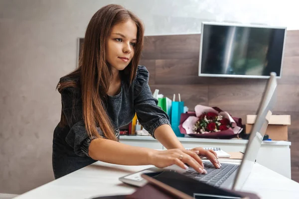 Young woman went to laptop and writes a message