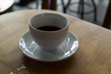 Bir fincan kahve, ahşap masa, üst manzara.