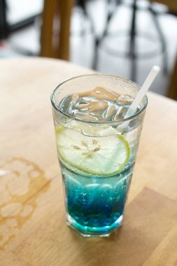 Kafedeki ahşap barda mavi İtalyan gazozu, seçici odak