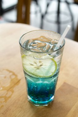 Kafedeki ahşap barda mavi İtalyan gazozu, seçici odak