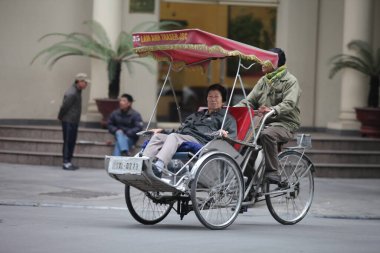 Geleneksel bisiklet sürüşü Hanoi, Vietnam sokaklarında. Bisiklet, 19 Eylül 2019 'da Fransız sömürgesi döneminde Vietnam' da ortaya çıkan üç tekerlekli bisiklet taksisidir.