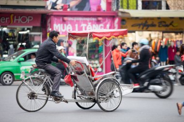 Geleneksel bisiklet sürüşü Hanoi, Vietnam sokaklarında. Bisiklet, 19 Eylül 2019 'da Fransız sömürgesi döneminde Vietnam' da ortaya çıkan üç tekerlekli bisiklet taksisidir.