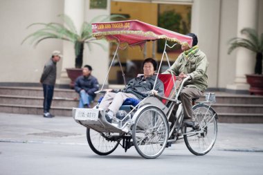 Geleneksel bisiklet sürüşü Hanoi, Vietnam sokaklarında. Bisiklet, 19 Eylül 2019 'da Fransız sömürgesi döneminde Vietnam' da ortaya çıkan üç tekerlekli bisiklet taksisidir.