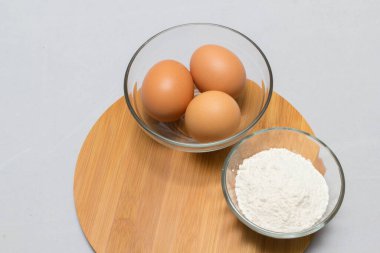 Beyaz masa arkasında yumurta ve un. temel pişirme arkaplanı.