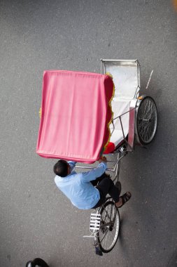Hanoi caddesinde bisiklet sürücüsü konik şapka takıyor