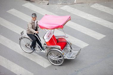 Hanoi caddesinde bisiklet sürücüsü konik şapka takıyor