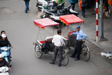 Hanoi caddesinde bisiklet sürücüsü konik şapka takıyor