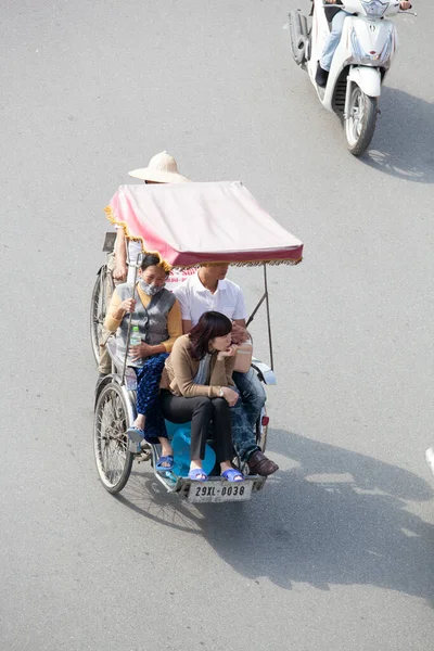 Hanoi caddesinde bisiklet sürücüsü konik şapka takıyor