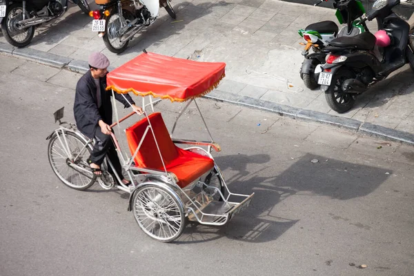 Hanoi caddesinde bisiklet sürücüsü konik şapka takıyor