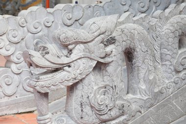 Vietnam 'daki taş ejderha heykeli mavi gökyüzü arka planında. Sol taraf manzaralı. Vietnam mitolojisinin ve folklorunun sembolü. Din, kültür ve Asya sanatı.