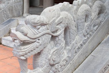 Vietnam 'daki taş ejderha heykeli mavi gökyüzü arka planında. Sol taraf manzaralı. Vietnam mitolojisinin ve folklorunun sembolü. Din, kültür ve Asya sanatı.