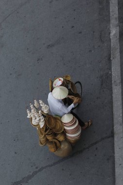 Hanoi, Vietnam - 15 Ekim 2016. Hanoi, Vietnam sokaklarında bisikletli bir sokak satıcısı. Başkentteki yoğun trafiğin ortasında geleneksel şapkalar satmak.