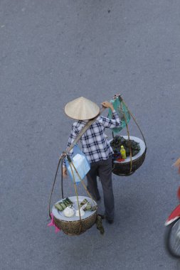 Hanoi, Vietnam - 15 Ekim 2016. Hanoi, Vietnam sokaklarında bisikletli bir sokak satıcısı. Başkentteki yoğun trafiğin ortasında geleneksel şapkalar satmak.