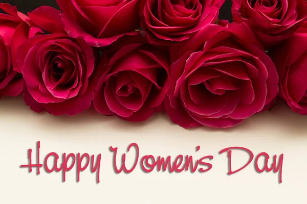 Mutlu Kadınlar Günü. 8 Mart. Kırmızı güllerle beyaz karta yazılmış.