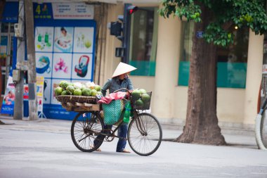 Hanoi, Vietnam - 21 Kasım 2019: Sokak satıcıları Hanoi, Vietnam 'da küçük bir mahallede müşteri bulmak için acele bir şekilde caddenin karşısına geçiyorlar