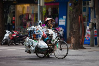 Hanoi, Vietnam - 21 Kasım 2019: Sokak satıcıları Hanoi, Vietnam 'da küçük bir mahallede müşteri bulmak için acele bir şekilde caddenin karşısına geçiyorlar