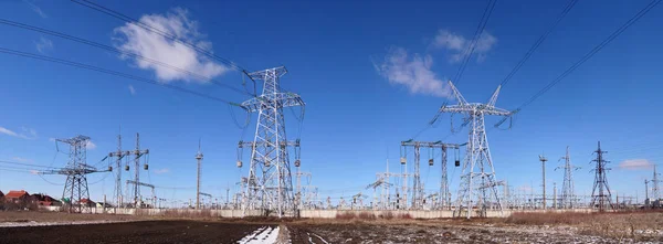 Yüksek voltajlı alt istasyonun panoramik görüntüsü. Dağıtım elektriği. Sütunların ve kulelerin siluetleri.