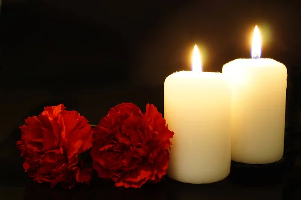 Zwei brennende Kerzen mit Blumen. — Stockfoto