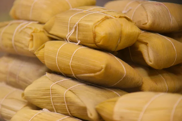 Pamonha (sweet corn cake) made from cooked green corn and wrapped in corn husks. Traditional Brazilian dish for June festival. Tamales