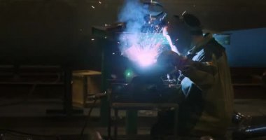 Ağır çekim. Kaynakçı bir boru kaynak. Sparks. İnsanlarla. Kaynakçı. Sanayi. Fabrikada çalışmak. Boru kaynak. Kaynakçı Kaynak maskesi, iş giyisi fabrikada, fabrika odasında boru kaynak. 