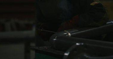 Kaynakçı. Sanayi. Fabrikada çalışmak. Boru kaynak. Electrode.Sparks. kaynak işleri. Yarı otomatik kaynak. Gaz kaynak. Ağır çekim. Kaynakçı Kaynak maskesi, iş giyisi fabrikada, fabrika odasında boru kaynak. . Grubu.