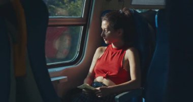 Elinde biletlerle trende oturan kadın