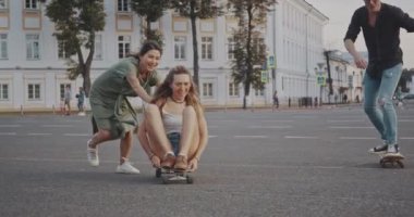 Arkadaşlar gün batımında kaykay üzerinde birlikte eğlenin